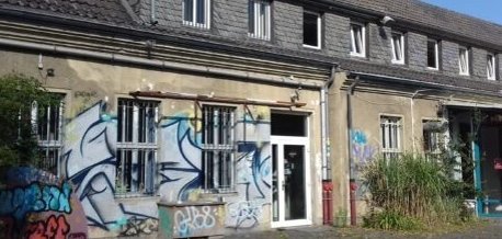 Ein etwas älteres Gebäude, das mit Graffiti beschmiert ist.