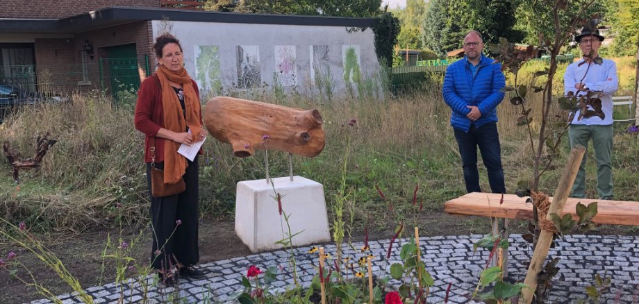 Frau steht vor dem neuen Treffpunkt und redet. Bürgermsister Roger Nießen daneben.