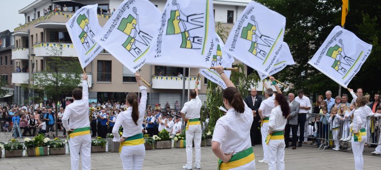 Einige Menschen schwenken eine Fahne vor Zuschauern