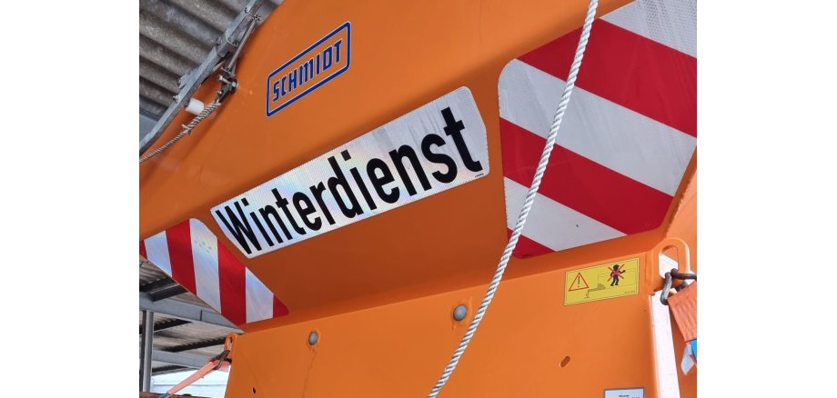 Winterdienstfahrzeug mit einem Schild Winterdienst.