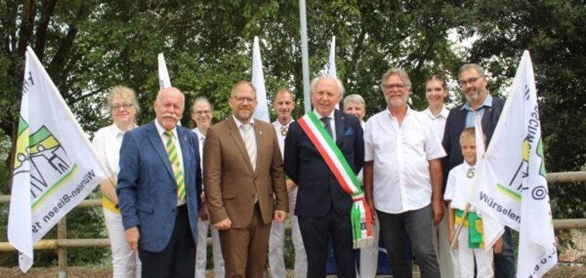 Bürgermeister Roger Nießen steht mit einigen Würselenern und mit seinen italienischen Freunden vor dem Würselen-Platz in Campaagnatico.