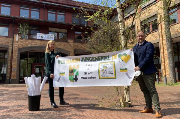 Kathrin Hensen und Bürgermeiter Roger Nießen zeigen das Banner "Wir haben Jungenspiel im Herzen"